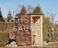 an outdoor sauna with the words out door in front of it and bushes around it