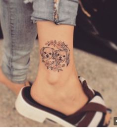 a small tattoo on the ankle of a woman's foot with two koala bears