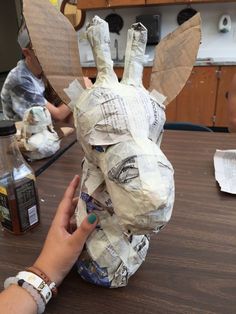 someone is making a paper mache animal out of newspaper