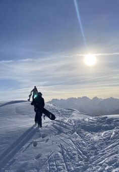 a man riding skis down the side of a snow covered slope under a blue sky