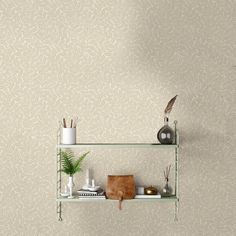 a shelf with some plants and other items on it in front of a wallpapered background