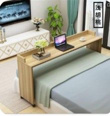 a bed with a laptop on top of it in front of a tv and window