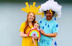 a man and woman dressed in costumes holding a baby