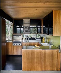 a kitchen with wooden cabinets and stainless steel counter tops is seen in this image from the doorway