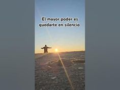 a man standing on top of a sandy beach next to the ocean with his arms wide open