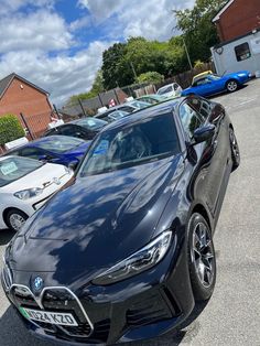 a black car parked in a parking lot next to other cars