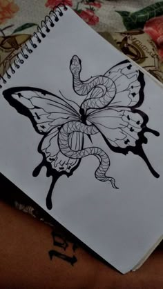 a drawing of a butterfly on top of a notebook