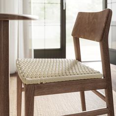 a wooden chair with a woven seat pad