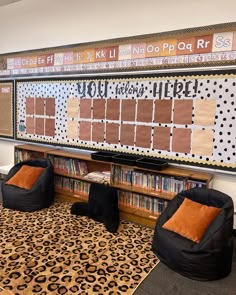 a library with leopard print rugs and black bean bag chairs in front of a bulletin board