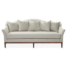 a white couch with lots of pillows on it's back and arms, against a white background