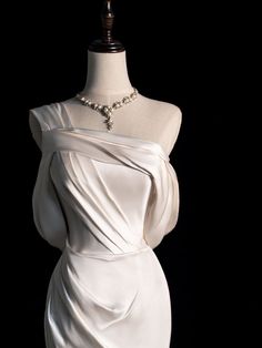 a white dress on a mannequin with pearls