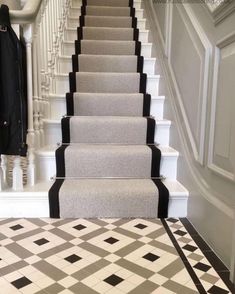 a carpeted staircase with black and white tiles