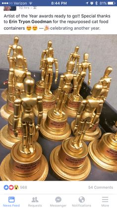 a group of golden figurines sitting on top of each other in front of a black table