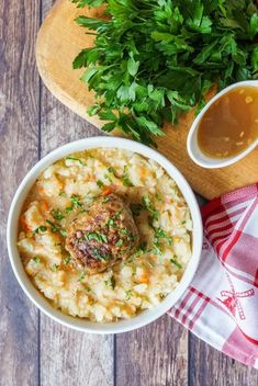 a bowl of mashed potatoes with meatballs and gravy on the side