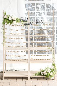 a white bench with flowers and greenery on it