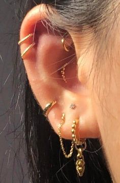 a woman wearing ear piercings with gold chains