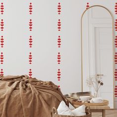 a bedroom with red hearts on the wall next to a chair and table in front of a mirror