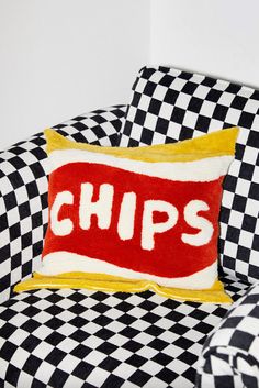 a black and white checkered chair with a red pillow that says chips on it