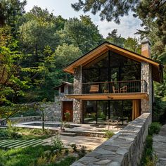 a house in the woods with stone walls and steps leading up to it's entrance