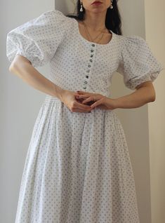 Incredible and super gorgeous vintage cotton dress. Pure white cotton with delicate light blue flowers. Adorable enamel buttons and gorgeous puff sleeves. Fluffy layered skirt, midi length. Stunning details. 100% cotton Excellent vintage conditions. Shoulder to shoulder 33 cm (plus the puff sleeve) Bust 42 cm Waist 36 cm Length 123 cm Best fit size X and S Model's size 6 uk, h 163 cm. Puff Sleeve Cotton Dress, White Puff Sleeve Vintage Dress For Summer, White Puff Sleeve Vintage Dress For Spring, White Vintage Dress With Buttons For Spring, Vintage Puff Sleeve Summer Dress For Daywear, Vintage Puff Sleeve Dress For Summer Daywear, White Midi-length Cottagecore Vintage Dress, White Midi Length Cottagecore Vintage Dress, Cottagecore Prairie Dress With Puff Sleeves For Daywear