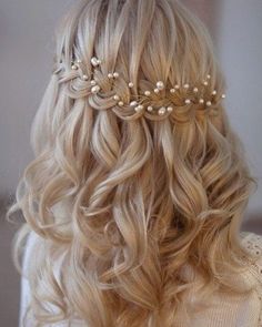 the back of a woman's head with long blonde hair and pearls on it