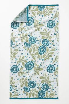 a blue and green floral print blanket on a white background