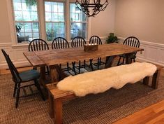 a dining room table with chairs and a bench