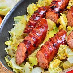 two sausages and cabbage in a pan on a table