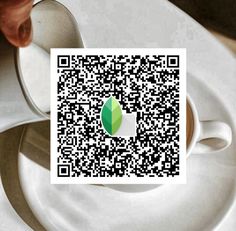 a person holding a spoon over a white plate with a qr code on it