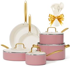 pink pots and pans with gold handles are shown in front of a white background