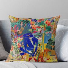 a painting on a pillow that has been placed on a couch with pillows and throw pillows