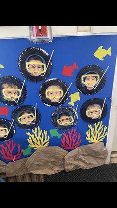 a bulletin board with pictures of children's faces and corals in the ocean