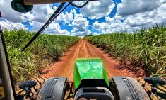 a view from the front seat of a vehicle driving down a dirt road