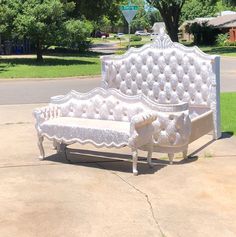 a white couch sitting on top of a sidewalk