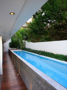 an outdoor swimming pool with wooden decking