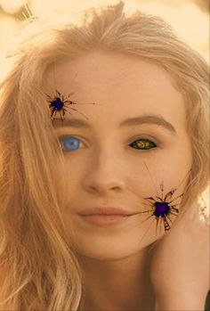 a woman with blue eyes and spider webs on her face is looking at the camera