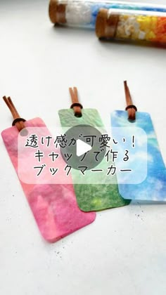 four small tags with japanese writing on them sitting next to some crayon markers