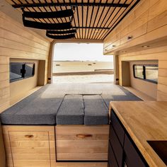 the inside of a small camper that is made out of wood and has drawers