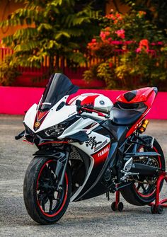 a red and white motorcycle parked on top of a parking lot