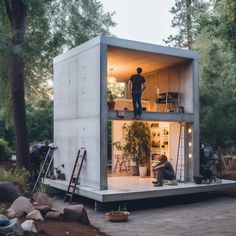 a man is standing on the roof of a tiny house with plants in it's windows