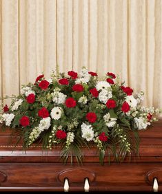 a casket with red and white flowers in it