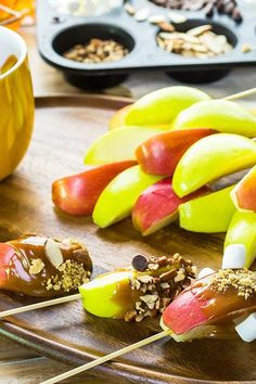 apples, bananas and other fruit on sticks with toppings