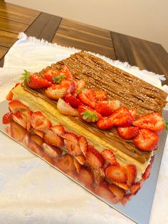 a cake with strawberries on it sitting on a table