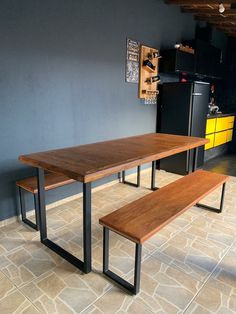 a wooden table and bench in a room with tile flooring on the ground, next to a refrigerator