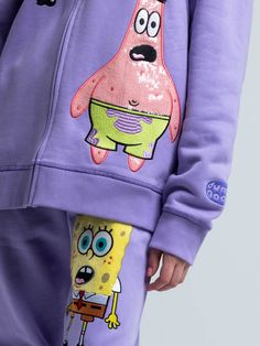 a person wearing spongebob shorts and a purple hoodie with cartoon characters on it