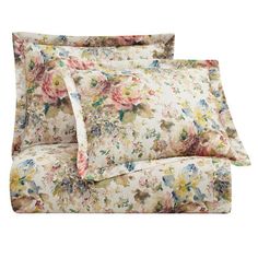 a bed with floral sheets and pillowcases on top of eachother,