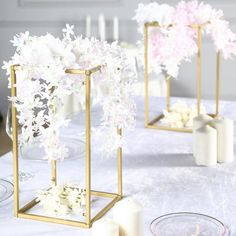 white and gold centerpieces on a table with candles