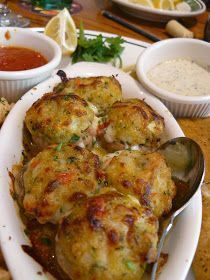 some food is sitting on a white plate with silver spoons and dipping sauces