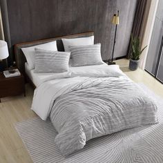 the bed is made with black and white linens, along with some throw pillows