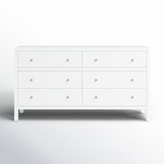 a white dresser with gold knobs on it